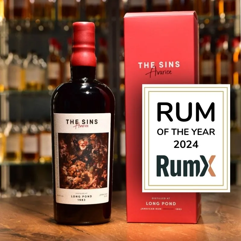 The Distilia The Sins Avarice bottle beside its red box and a RumX Rum of the Year 2024 plaque.