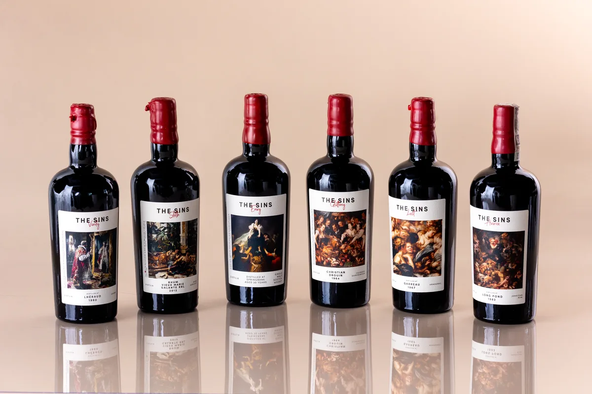 Six bottles from the Distilia The Sins series lined up, each with a classical painting on the label.