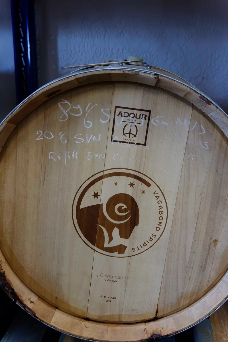 Cask head branded with the Vagabond Spirits logo and the stamp of the Adour cooperage, chalk notes written above it.