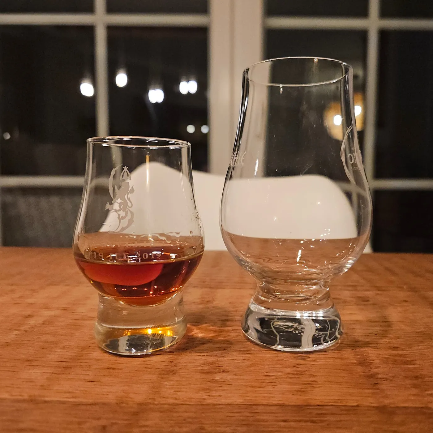 Mini Glencairn with rum next to a full-size Glencairn on a wooden table