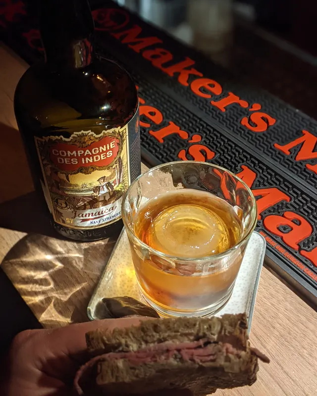 Old Fashioned from above, next to a bottle of Compagnie des Indes and a sandwich