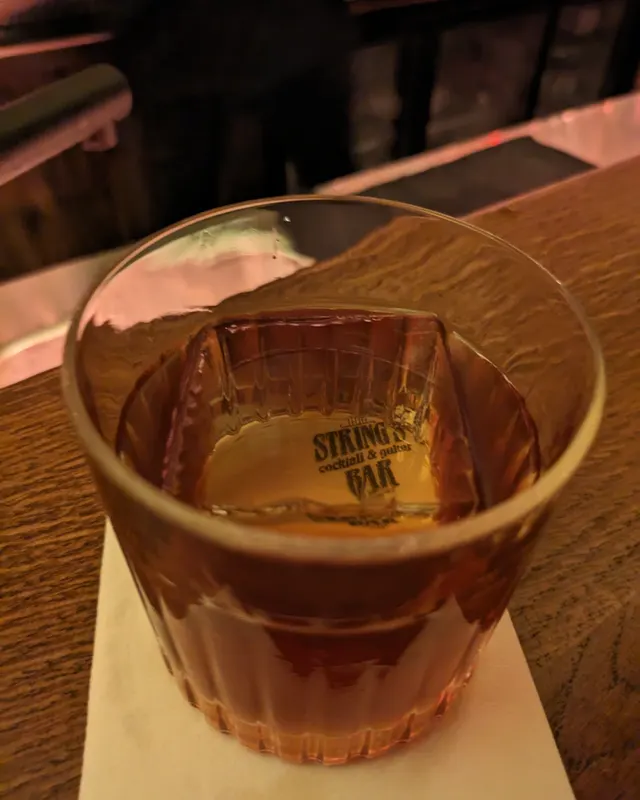 Old Fashioned in a ribbed glass with a branded ice cube