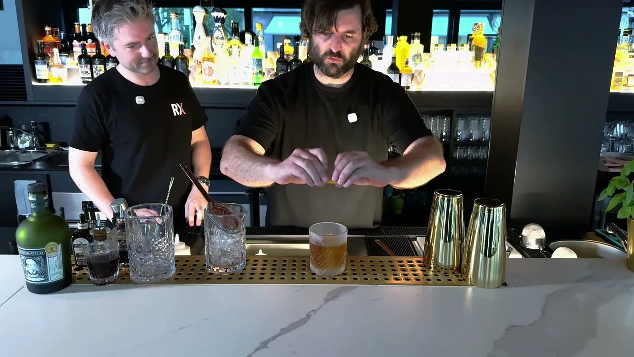 Stefan Glück expresses the orange zest over the finished Diplomático Old Fashioned, with the bottle visible on the left